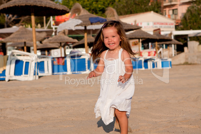 kleines süßes mädchen spielt lachen am Strand im Sommer