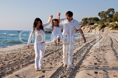 glückliche junge familie mit kleiner Tochter am Strand am wasse