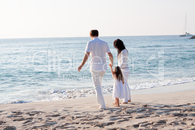 glückliche junge familie mit kleiner Tochter am Strand am wasse