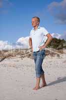 Junger mann entspannt am Strand am Wasser im Sommer