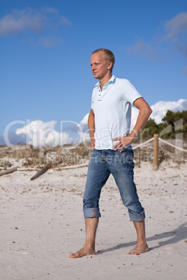 Junger mann entspannt am Strand am Wasser im Sommer