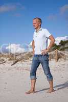 Junger mann entspannt am Strand am Wasser im Sommer