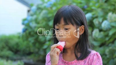 Asian Girl Eating A Popsicle