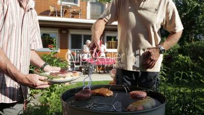 detail senior men putting meat on grill