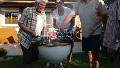 four seniors having barbecue in garden