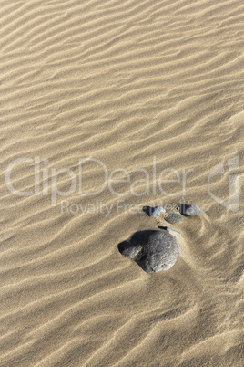 Steine im welligen Sand - Hochformat
