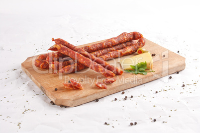 Wooden chopping board with sausages and spices