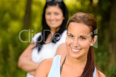 Teen girl smiling with mother in background