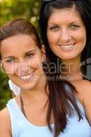 Portrait of mother and daughter smiling outdoors