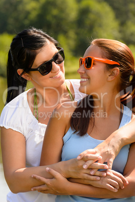 Mother and daughter relaxing in park smiling
