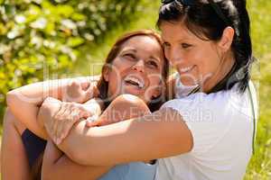 Mother holding daughter in her arms laughing