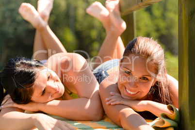 Mother and daughter sunbathing smiling teen friend