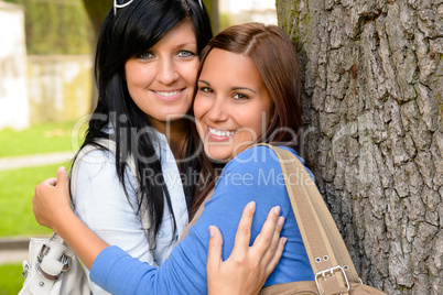 Mother and teen hugging outdoors relaxing smiling