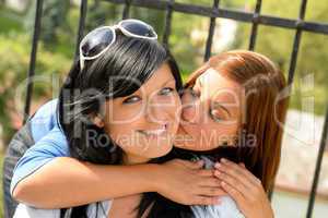 Daughter kissing her mother outdoors teen happy