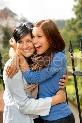 Mother kissing her daughter happy embrace outdoors