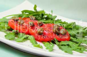 Salad with fresh tomatoes, capers and arugula