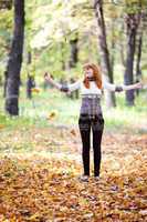 young redhead teenager throwing leaves woman in the forest