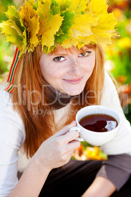 young redhead teenager woman in a wreath of maple leaves with cu