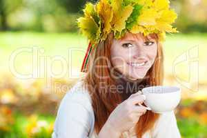 young redhead teenager woman in a wreath of maple leaves with cu
