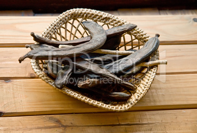 Dry Organic Carob Pods In A Straw Basket