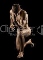 Naked strong man posing in gold skin