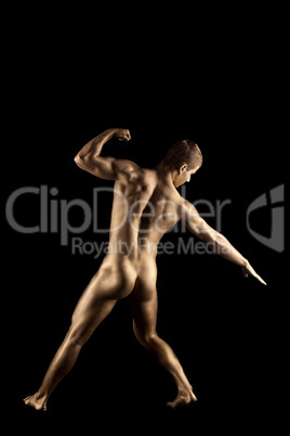 Naked strong man posing like metal skin statue