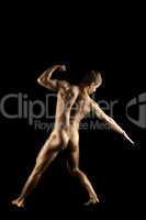 Naked strong man posing like metal skin statue