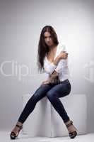 Beauty woman sit in jeans and undress white jacket