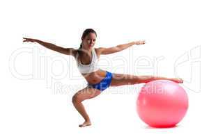 Young woman doing split with fitness ball isolated