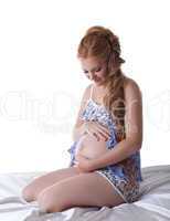 Beautiful pregnant woman sit in silk bed