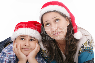 Mother and son in Santa hats smiling and looking up Mother and son in Santa hats smiling and looking up