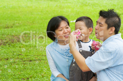 Asian family playing bubble wand