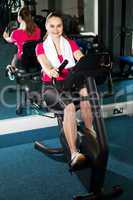 Pretty fit woman pedaling exercise bike fast