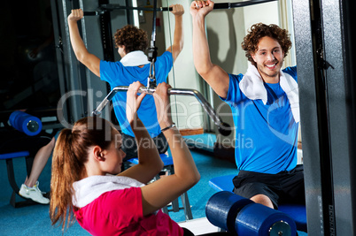 Friends working out together in a multi gym