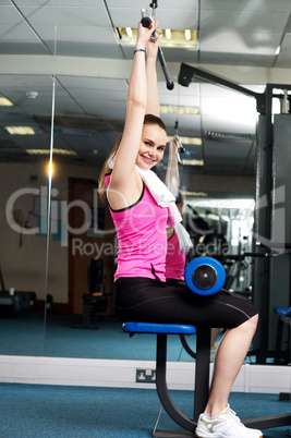 Woman toning her upper and core muscles in multi gym