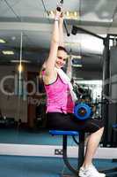 Woman toning her upper and core muscles in multi gym