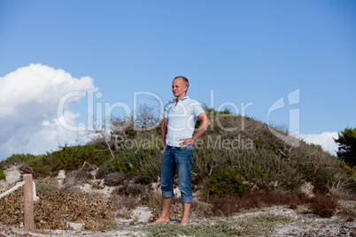 junger mann entspannt am strand in dünen