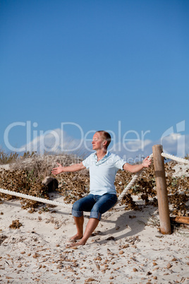 junger mann entspannt am strand in dünen