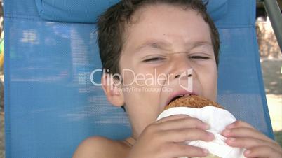 Little boy eating burger