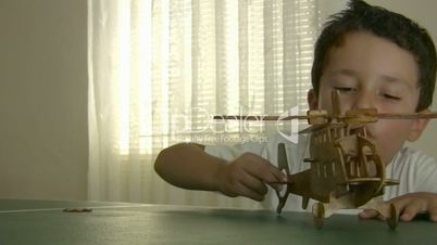 Little boy playing wooden helicopter