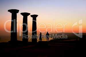 Two Tourists Watching The Sunset At The Athena Temple