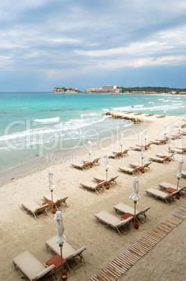 Sunbeds on a beach and turquoise water at the modern luxury hote