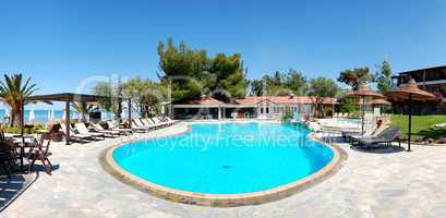 Panorama of swimming pool by beach at the modern luxury hotel, H