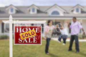 Sold Real Estate Sign and Hispanic Family in Front of House
