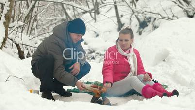 Couple Frying Sausages On Fire In The Winter Forest