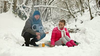 Teenage Couple  By Bonfire in Snow Forest