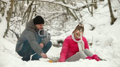 Teenagers Sitting by Bonfire in Winter Forest