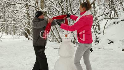 Building Snowman  In Winter Forest