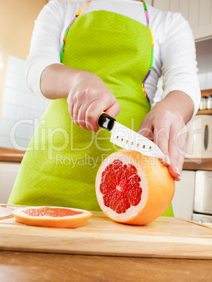 Woman's hands cutting grapefruit