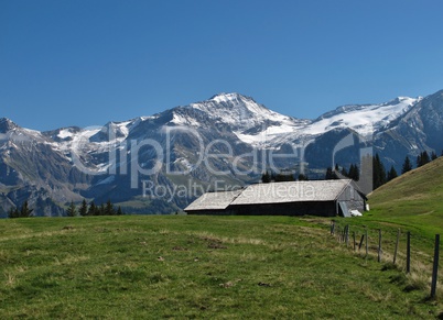 High Mountains And Old Hut With Traditional Timber Roof